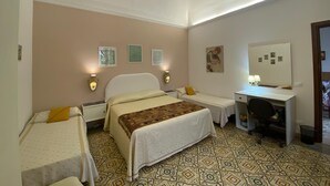 A hotel room with a bed, two bedside tables, a desk with a chair, and a mirror. - The House of Flowers, in the heart of the Gulf of Macari 2.5 km from the sea. (Castelluzzo)