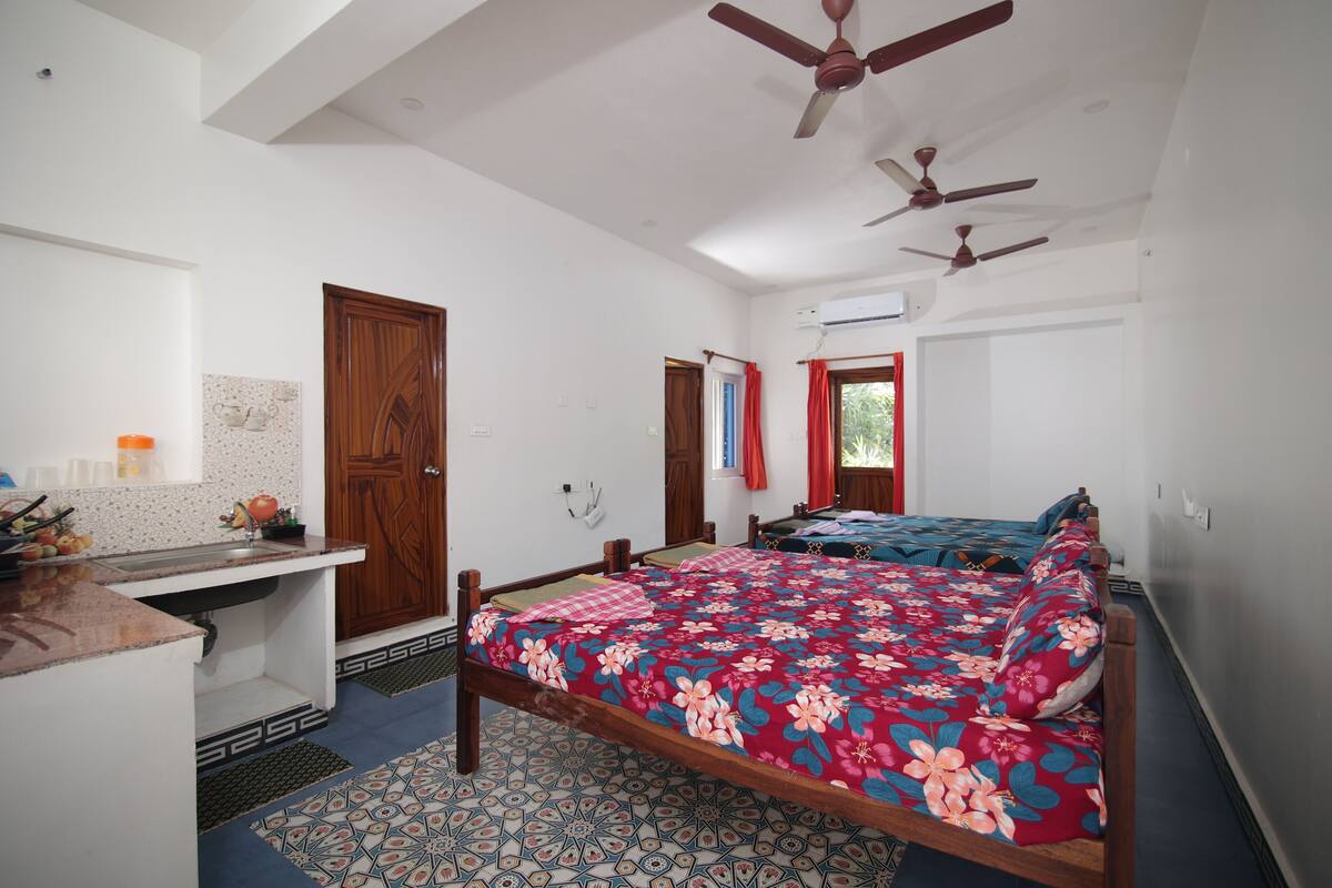 A bedroom with a bed, a desk, and a window.
