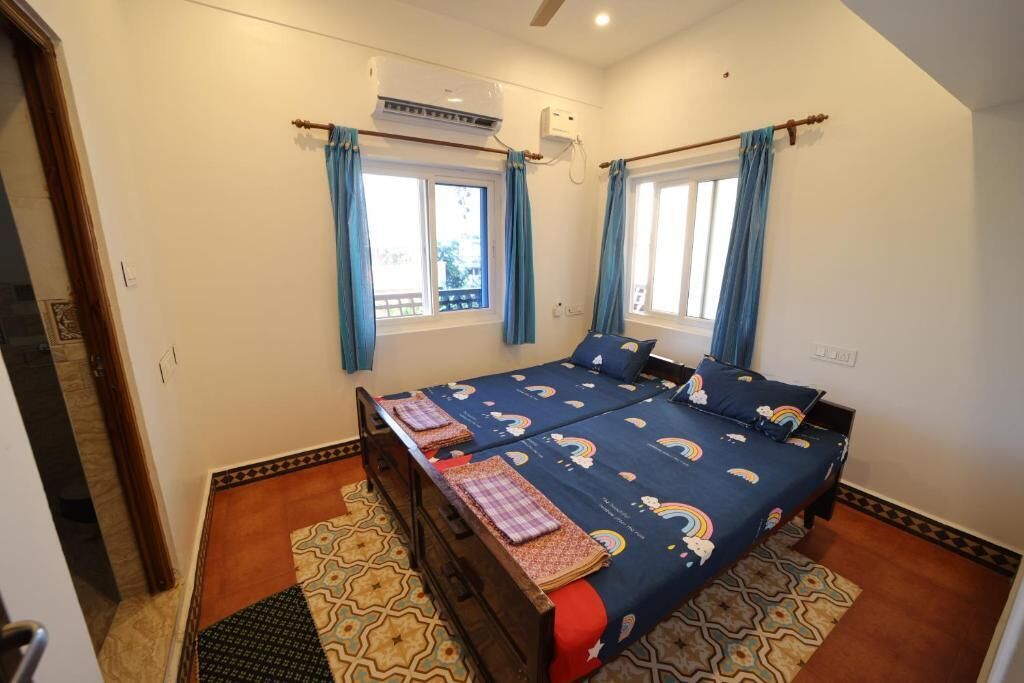 Un dormitorio con cama, aire acondicionado y ventana con cortinas.
