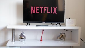 A television on a white stand with the word "NETFLIX" on the screen. - 4guests-parking-2br-familyfriendly (London)