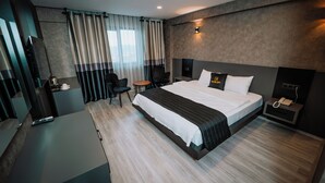 A modern hotel room with a large bed, a desk, a chair, and a bedside table with a phone. - Marlen Hotel Denizli (Denizli)