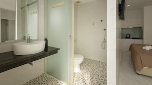 Een moderne badkamer met een grote spiegel, twee wastafels, een toilet en een douche.