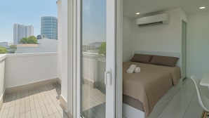 Een moderne slaapkamer met een bed, een tafeltje en een airconditioning.