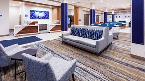 A modern hotel lobby with a reception desk, seating area, and a large TV screen. - Holiday Inn Express & Suites Senatobia I 55 by IHG (Senatobia)