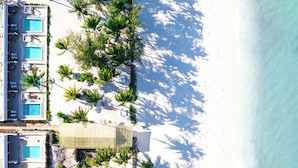 An aerial view of a resort with multiple swimming pools, palm trees, and a beach. - Orient Beach Hotel (Bwejuu)