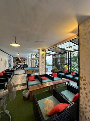 A modern lounge area with multiple seating options, including sofas and benches, arranged around a central table. - Blueskyhouse patong (Patong)