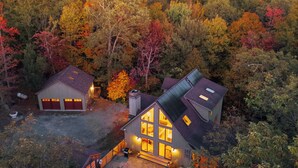A two-story house with a large glass front and a sloped roof, surrounded by dense forest. - Cold Spring Mountain Retreat: Secluded Oasis (Cold Spring)