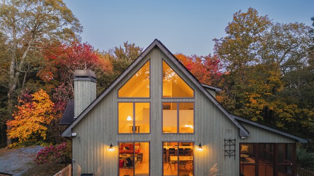 A wooden cabin with large windows, a stone patio, and outdoor seating. - Cold Spring Mountain Retreat: Secluded Oasis (Cold Spring)