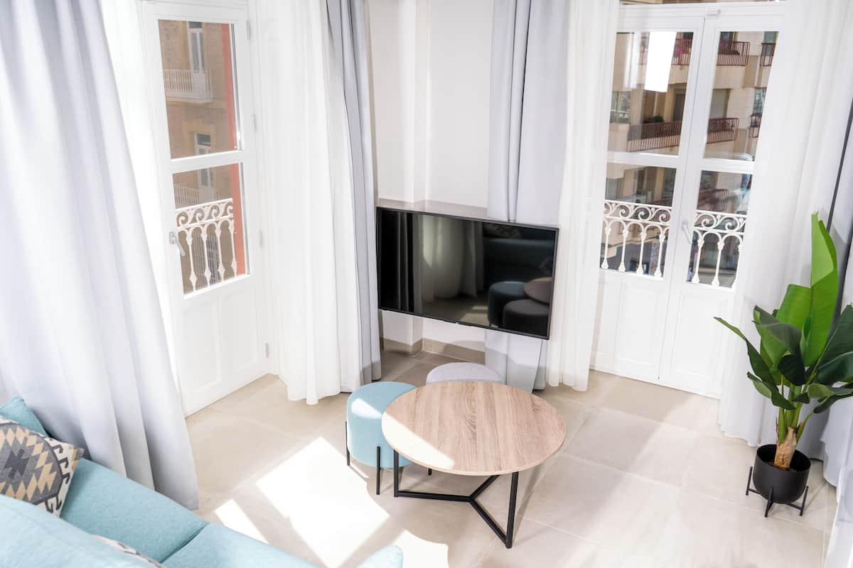 A modern living room with a TV, a round table, and a sofa.
