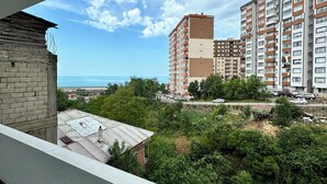 A high-rise building with multiple balconies overlooking a coastal area. - ÖZTÜRK VIP (Trabzon)