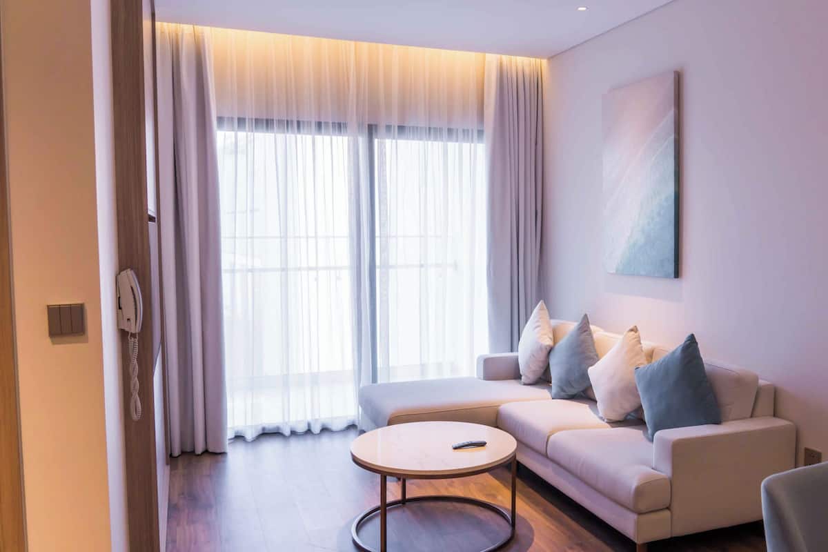 Un salon moderne avec un canapé, une table basse et un tableau accroché au mur.