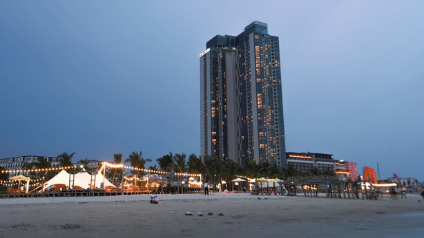 Ein hoch aufragendes Hotel mit mehreren Etagen in Strandlage.