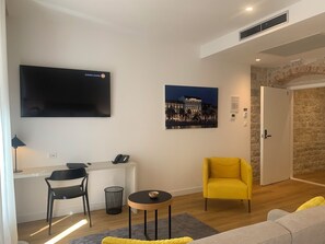 Suite – deluxe, 1 kingsize-seng med sovesofa, byutsikt | Oppholdsområde | TV og printere