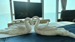 Ein Hotelzimmer mit Bett, Fernseher und Meerblick.