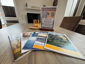 Een tafel met brochures, een kaars en een lijst met tekst.