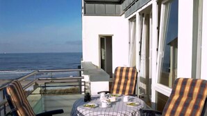 A balcony with a table set for two, overlooking the sea. - Meerzeit - im Kaiserhof Wangerooge (Wangerooge)