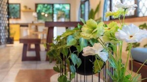 A cozy interior with a wooden floor, a white vase with flowers, and a hanging light fixture. - 5 min to Beach ~ Private Pool ~ European style! (Sardinal)