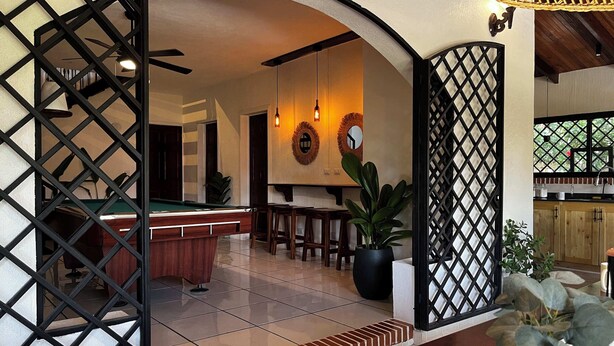 A pool table in a room with a wooden ceiling and a dining area with chairs and a table. - 5 min to Beach ~ Private Pool ~ European style! (Sardinal)