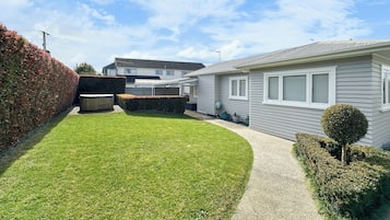 Stroll through the beautifully manicured lawn and approach the charming house with a pathway leading to the front door.