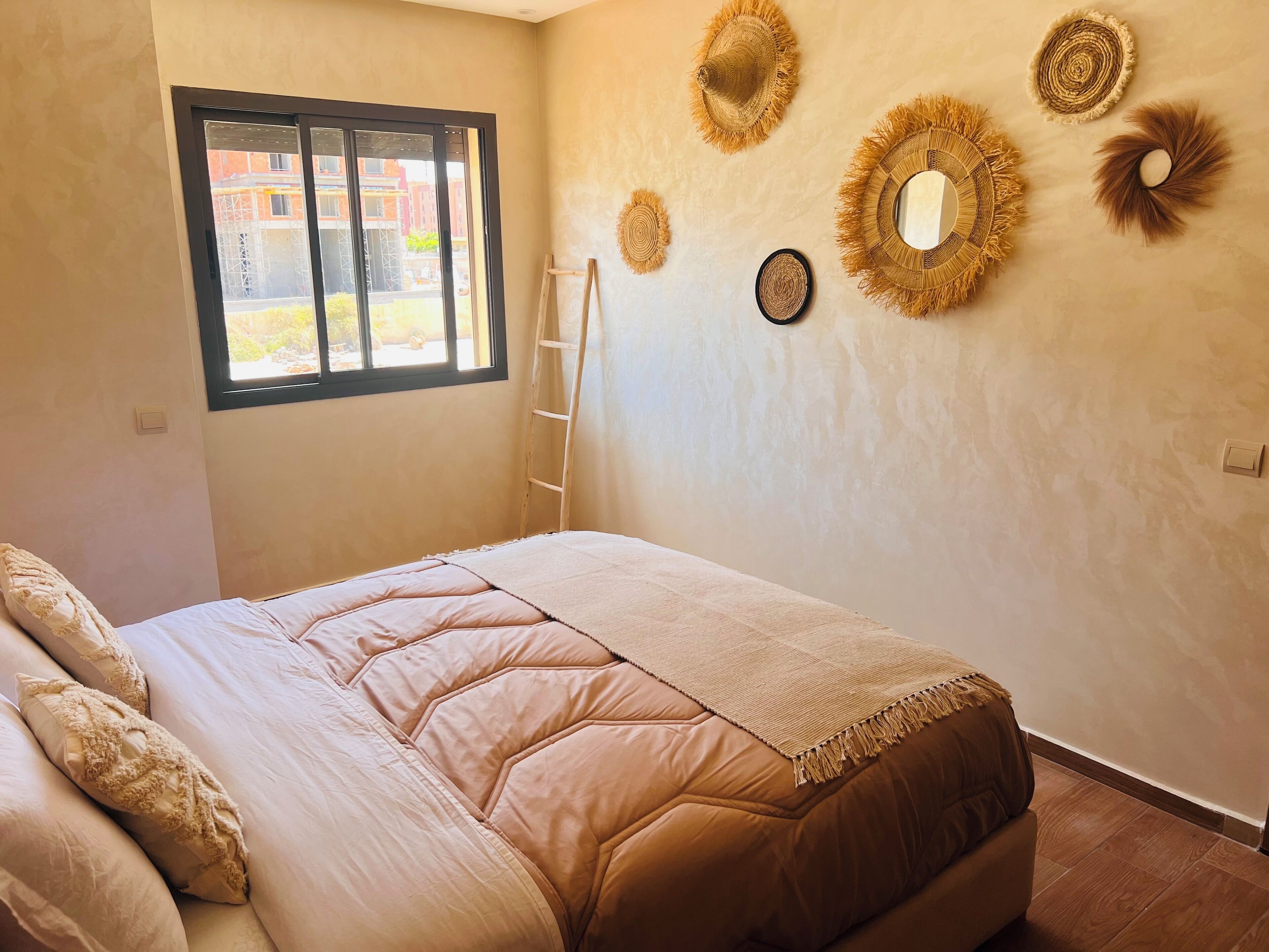 A bedroom with a bed, a window, and wall decor.