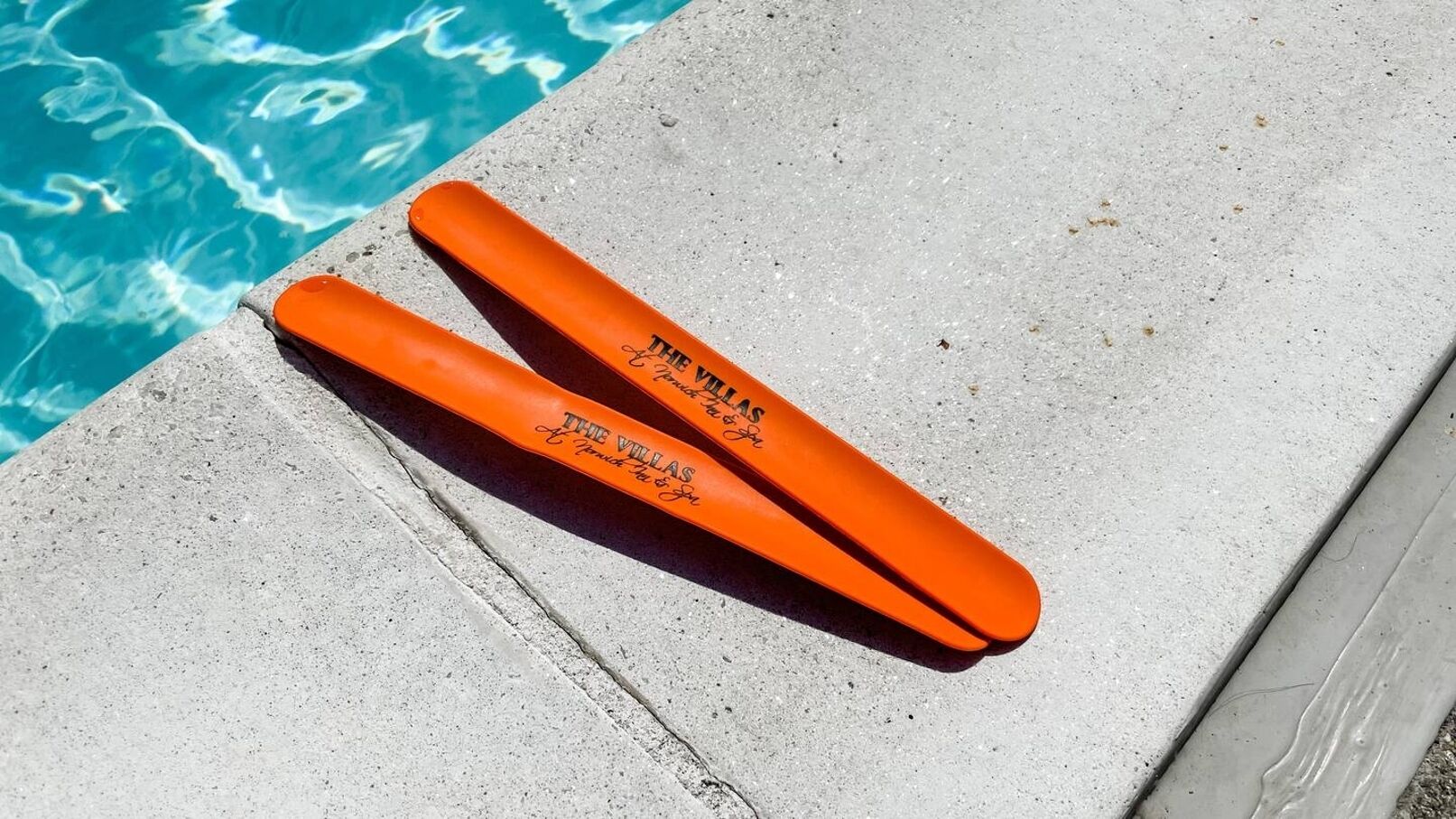 Two orange floating devices labeled "The Villas" by "A. Munch & Co" by a pool.