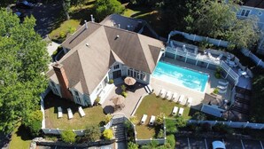 A house with a swimming pool, a covered patio, and a fenced yard.