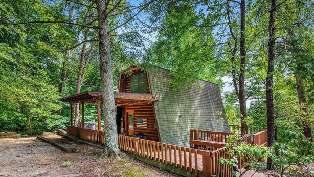 Une cabane avec une façade en bois, une véranda et une terrasse.