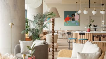 Un interior moderno con sofá, sillas, zona de comedor y cocina.
