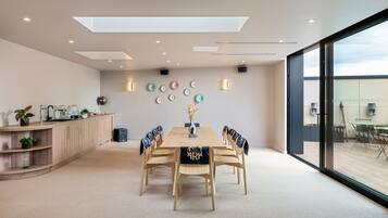 A modern meeting room with a wooden table, chairs, and a decorative wall.