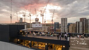 Un bar situé sur un toit, avec une terrasse et une vue sur la ville.