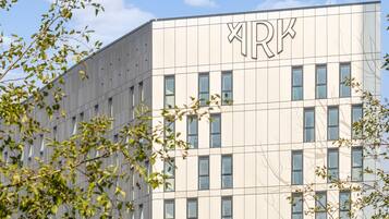 A modern building with a grid of windows and a large 'RK' sign on the facade.