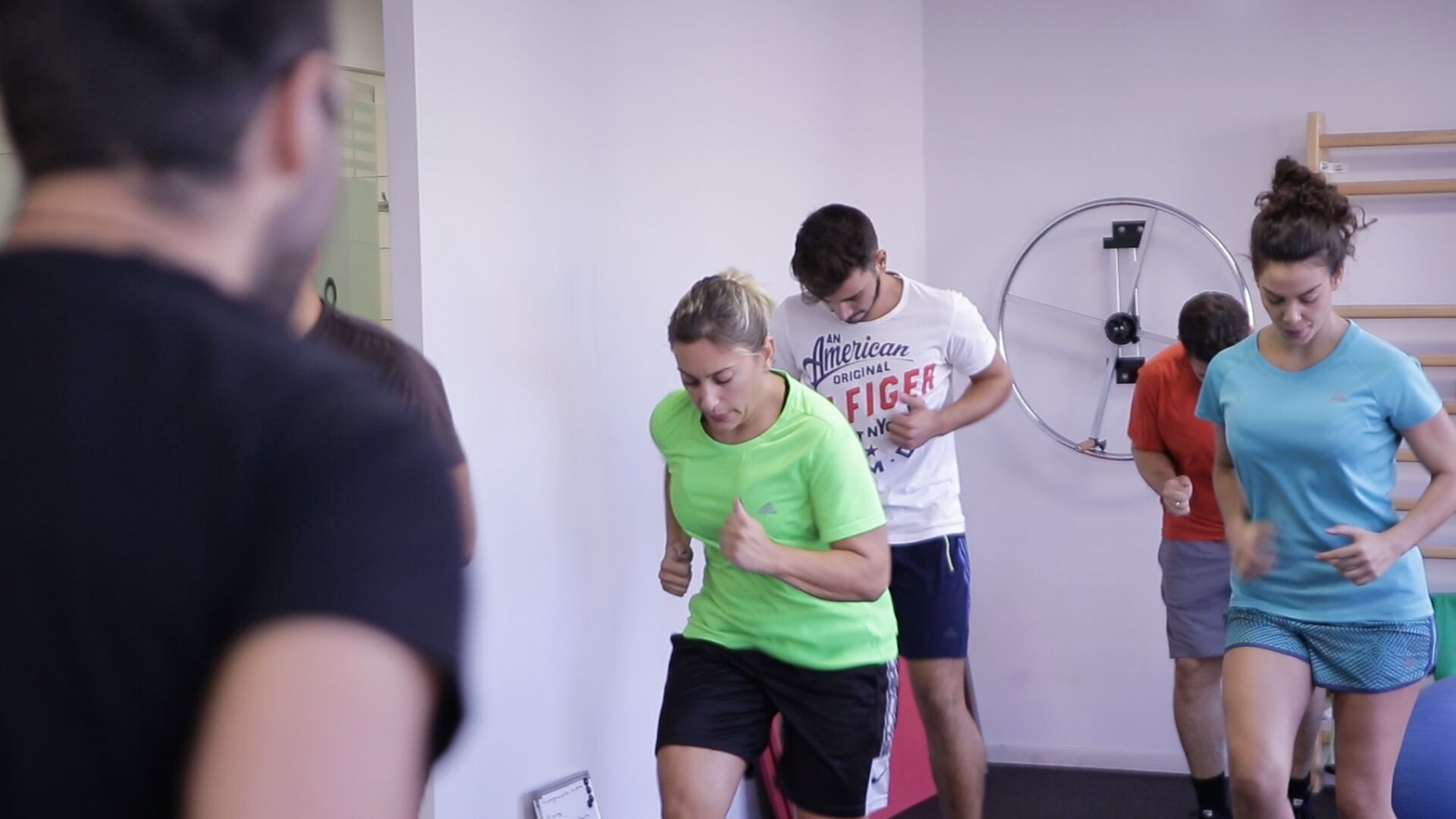 Un grupo de personas en un gimnasio, usando equipo de ejercicio.