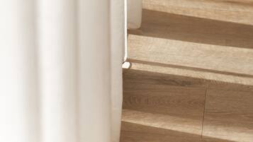 Una escalera de madera con cortinas blancas.