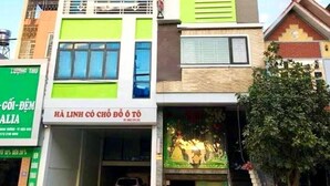 A multi-story building with a green and white facade, featuring a sign for "HA LINH HOTEL" at the top.