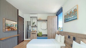 Ein modernes Hotelzimmer mit einem großen Bett, einem Kleiderschrank, einem Spiegel und einem Gemälde an der Wand.