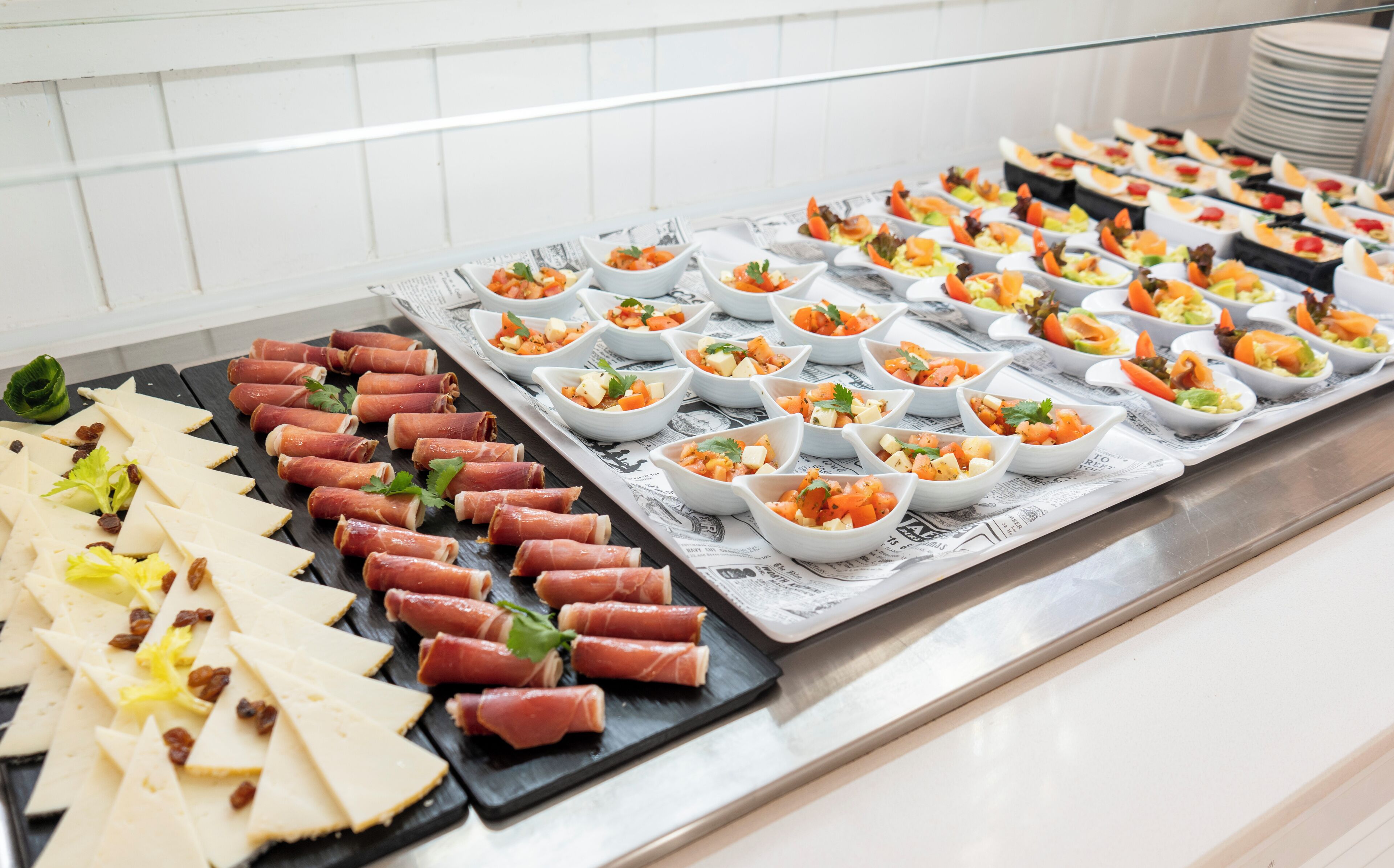 Un bufé con diversos alimentos, incluyendo carnes y ensaladas.
