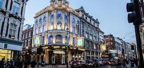 A historic theater building with classic architecture, a marquee, and a busy street scene.