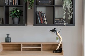 Work and unwind in this thoughtfully designed space, featuring a console table, bookshelf, and lush greenery.