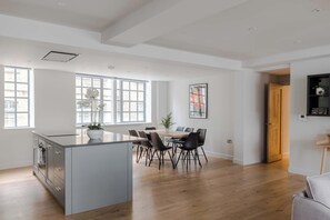 A spacious kitchen with a dining area, large windows, and a modern design.