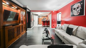 Een moderne woonkamer met een televisie, bank en een glazen salontafel.