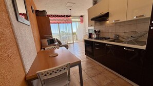 A kitchen with a dining area, a microwave, and a view of the outdoors.