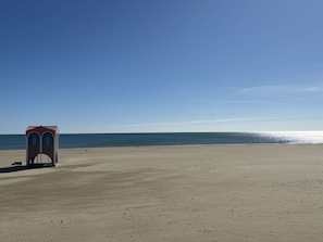 A beach with a small structure, possibly a lifeguard tower, and a clear sky. - Renovated 2-room apartment for 4 people with private garden - Beach a stone's throw away (Port-la-Nouvelle)