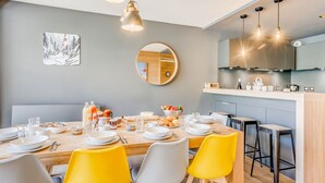 A modern kitchen with a central island, wooden cabinets, and a round mirror on the wall.