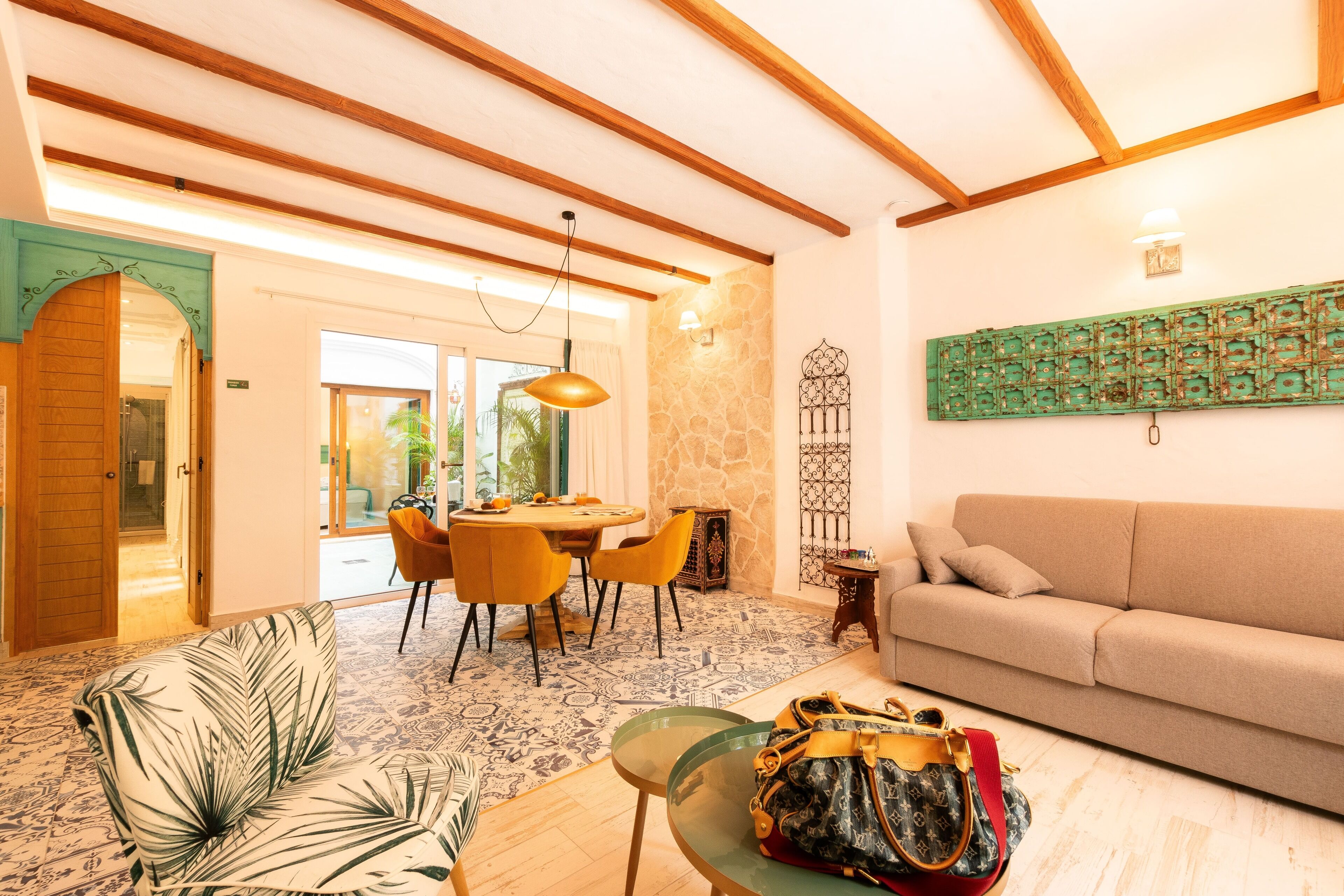 Una sala de estar moderna con un sofá, una mesa de centro de vidrio y un comedor con mesa y sillas.