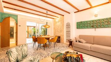 Una sala de estar moderna con un sofá, una mesa de centro de vidrio y un comedor con mesa y sillas.