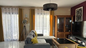 Una sala de estar con sofá, mesa de centro y mueble para televisión.