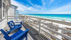A balcony with blue chairs overlooking a beach with white sand and turquoise water. - Seawinds 9 | Renovated Gulf-Front Escape (Mramar Beach)