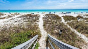 A beach path leading to a sandy beach with umbrellas and people. - Seawinds 9 | Renovated Gulf-Front Escape (Mramar Beach)