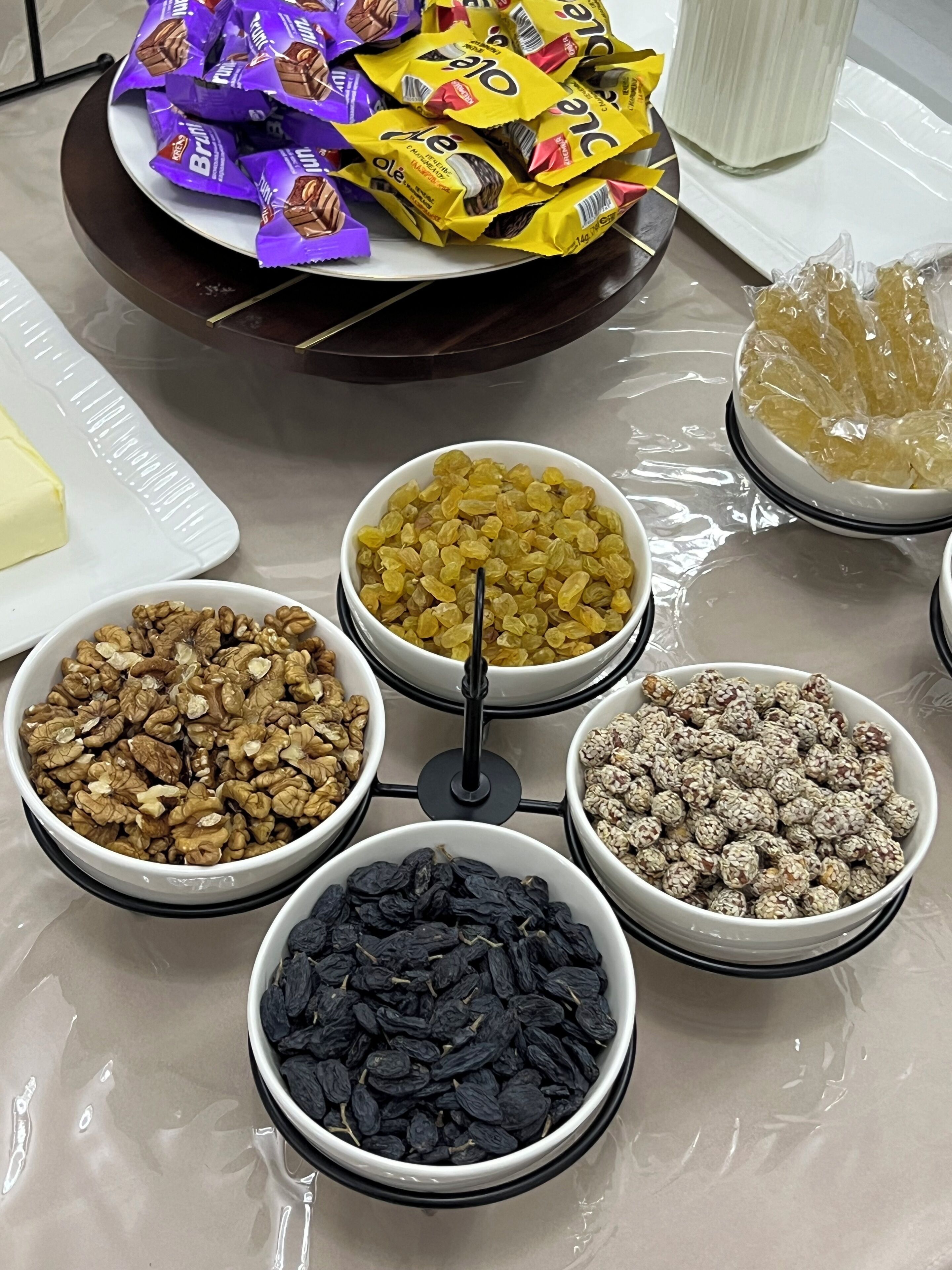 A buffet table with various food items including nuts, raisins, and chocolate bars.