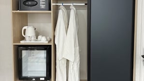 A modern wardrobe with a microwave, a coffee maker, and a glass cabinet. - DSF GARDEN HOTEL (Tashkent)